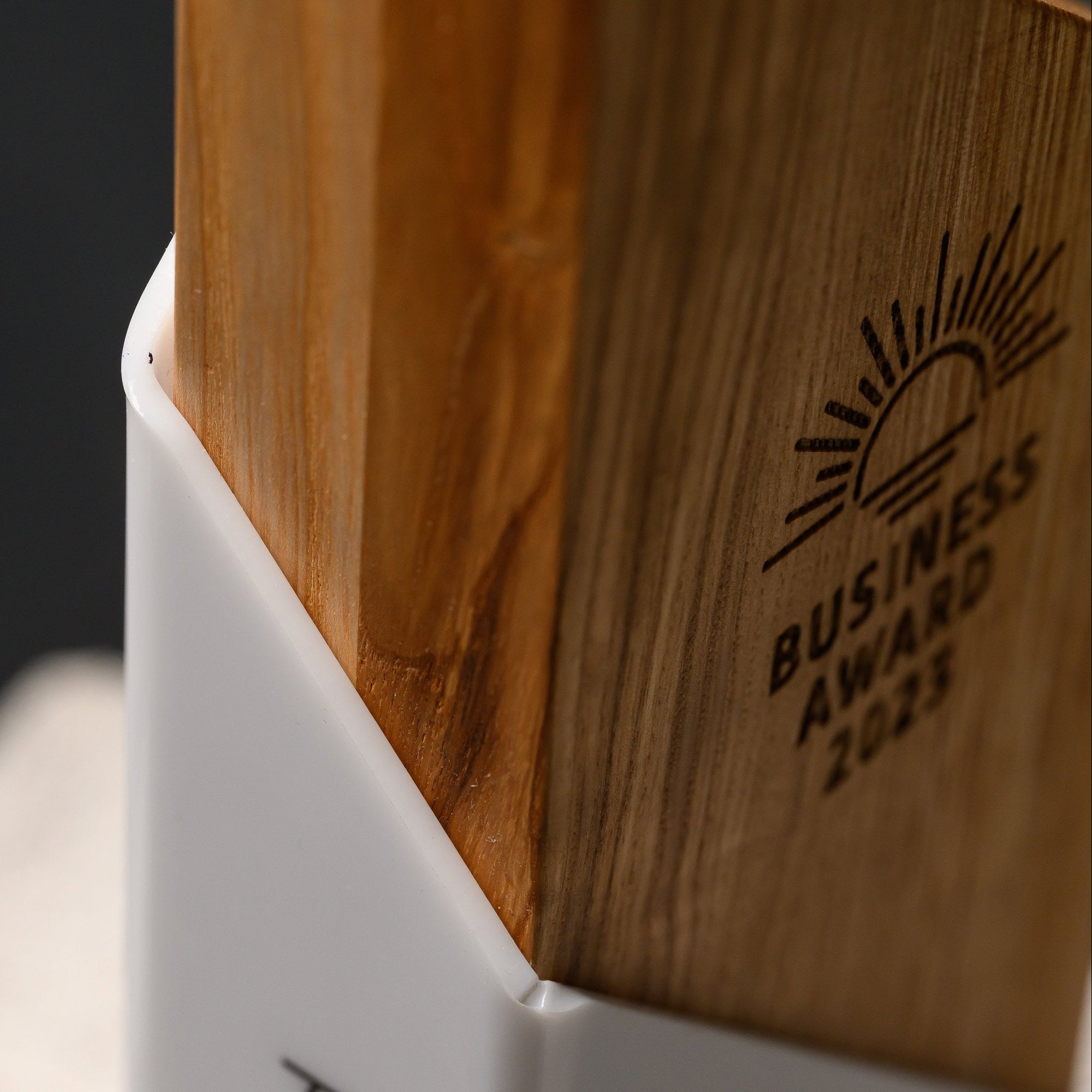 Macro of the join where the heat-formed acrylic sheet wraps tightly around the oak block