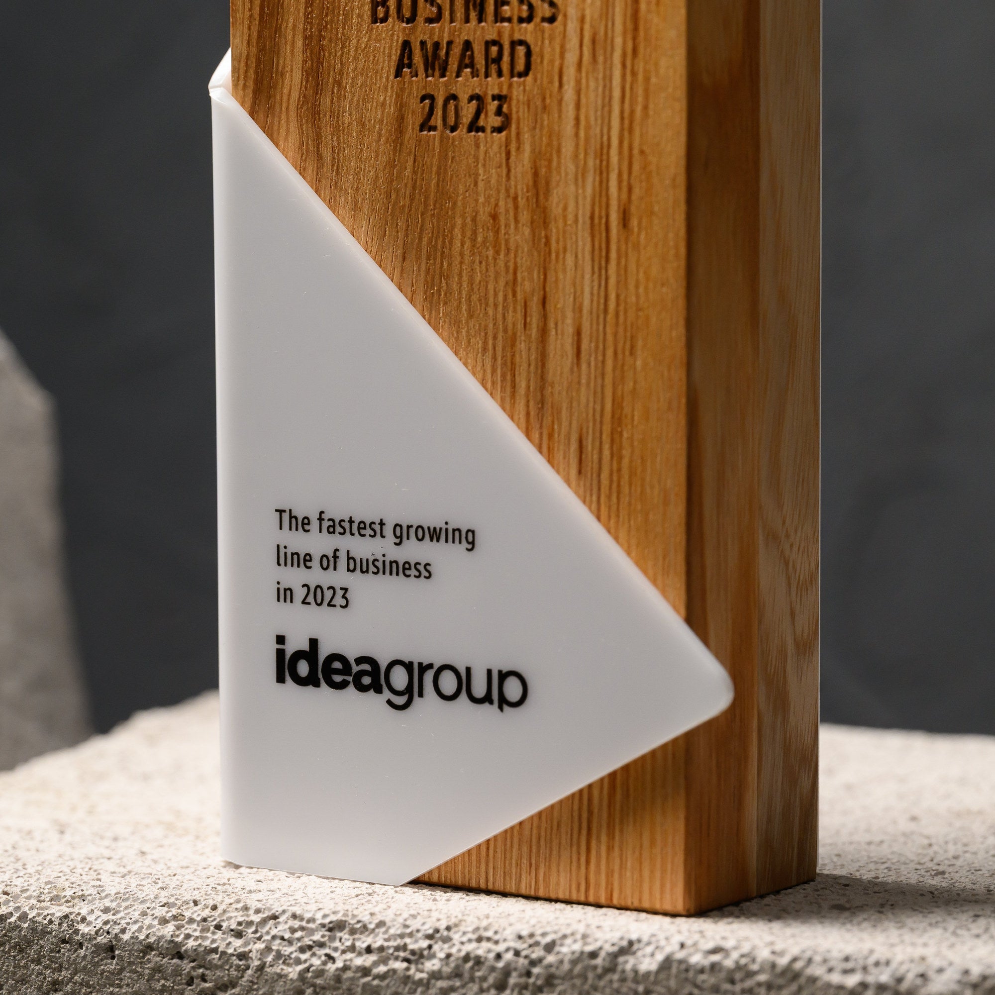 Front detail of the acrylic panel with UV-printed wording and logo below the engraved oak