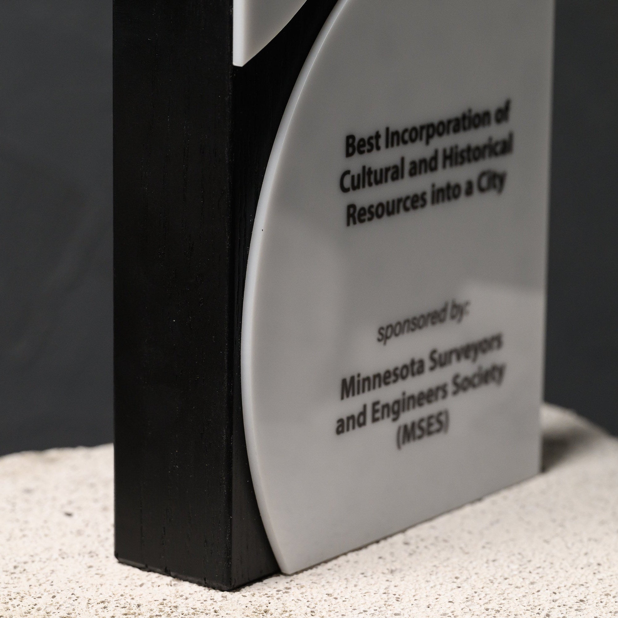 Lower acrylic disc carrying the category wording and sponsor line beside the black edge