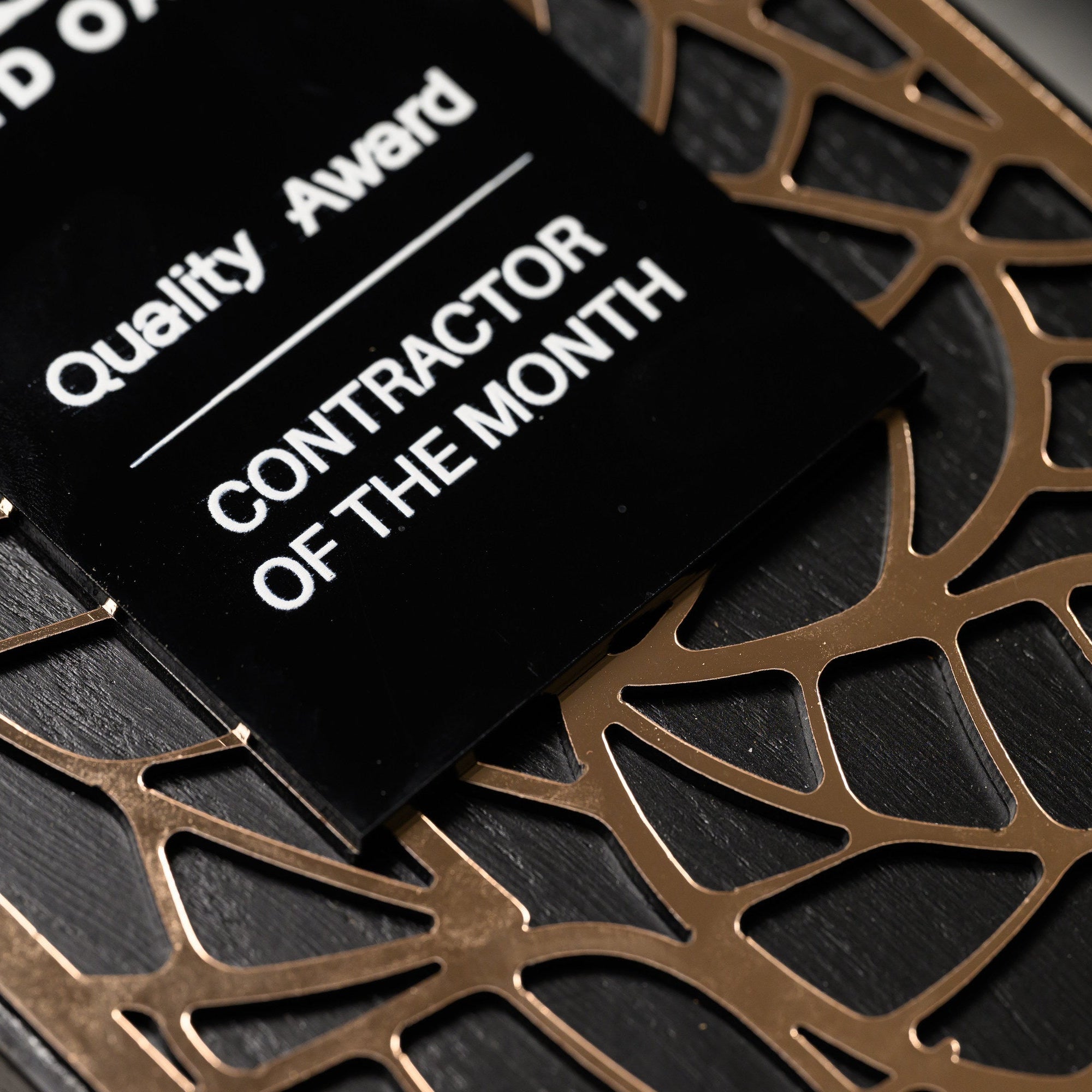 Close view of the printed black acrylic plate resting on the gold lattice