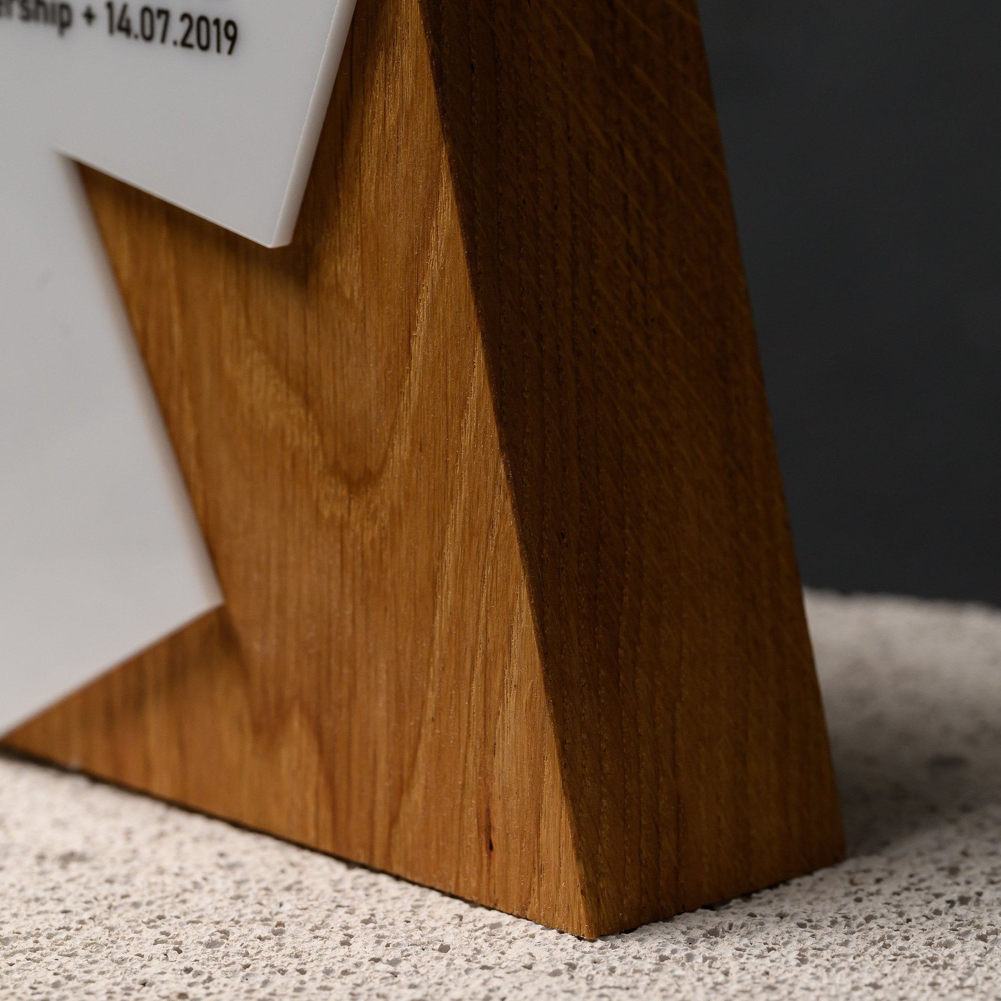Base of the award showing the tapered oak foot and the stepped join with the acrylic