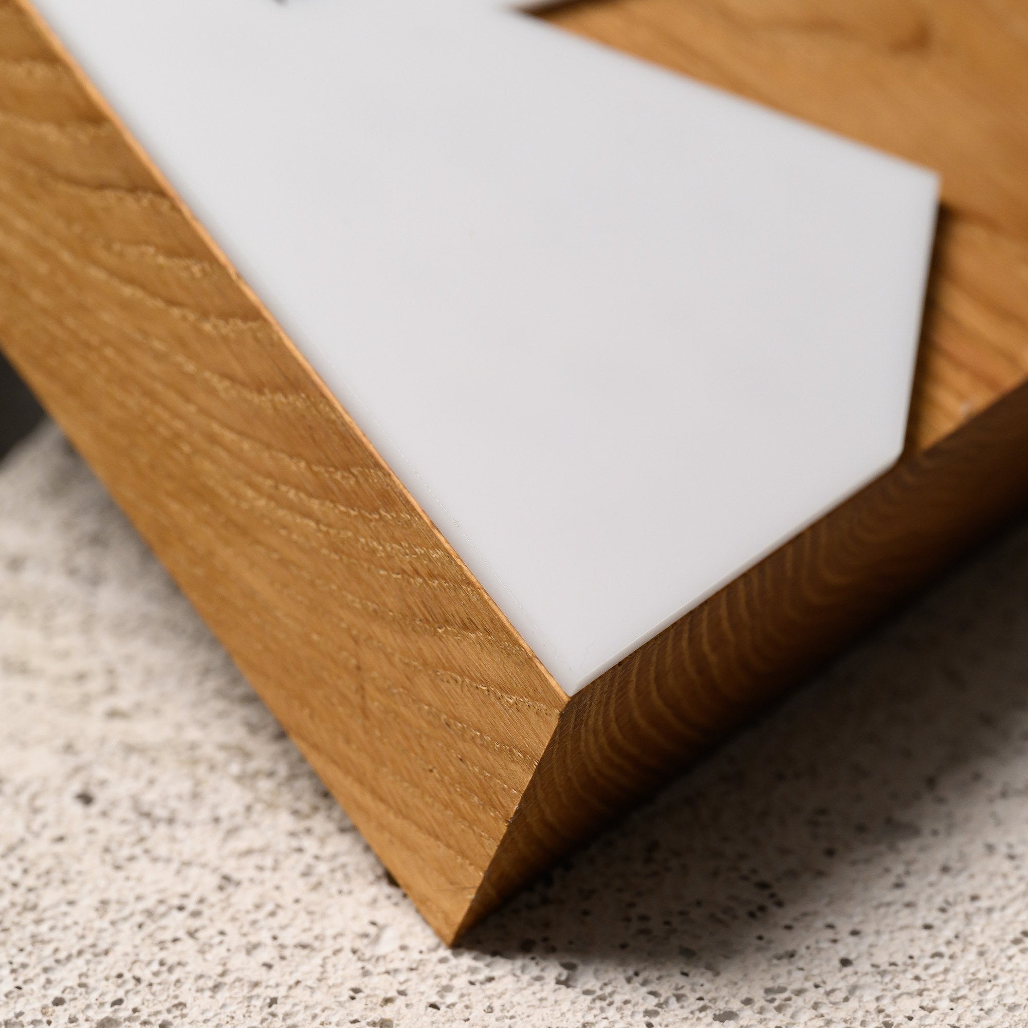 Low macro of the oak side edge and the thickness of the white acrylic panel