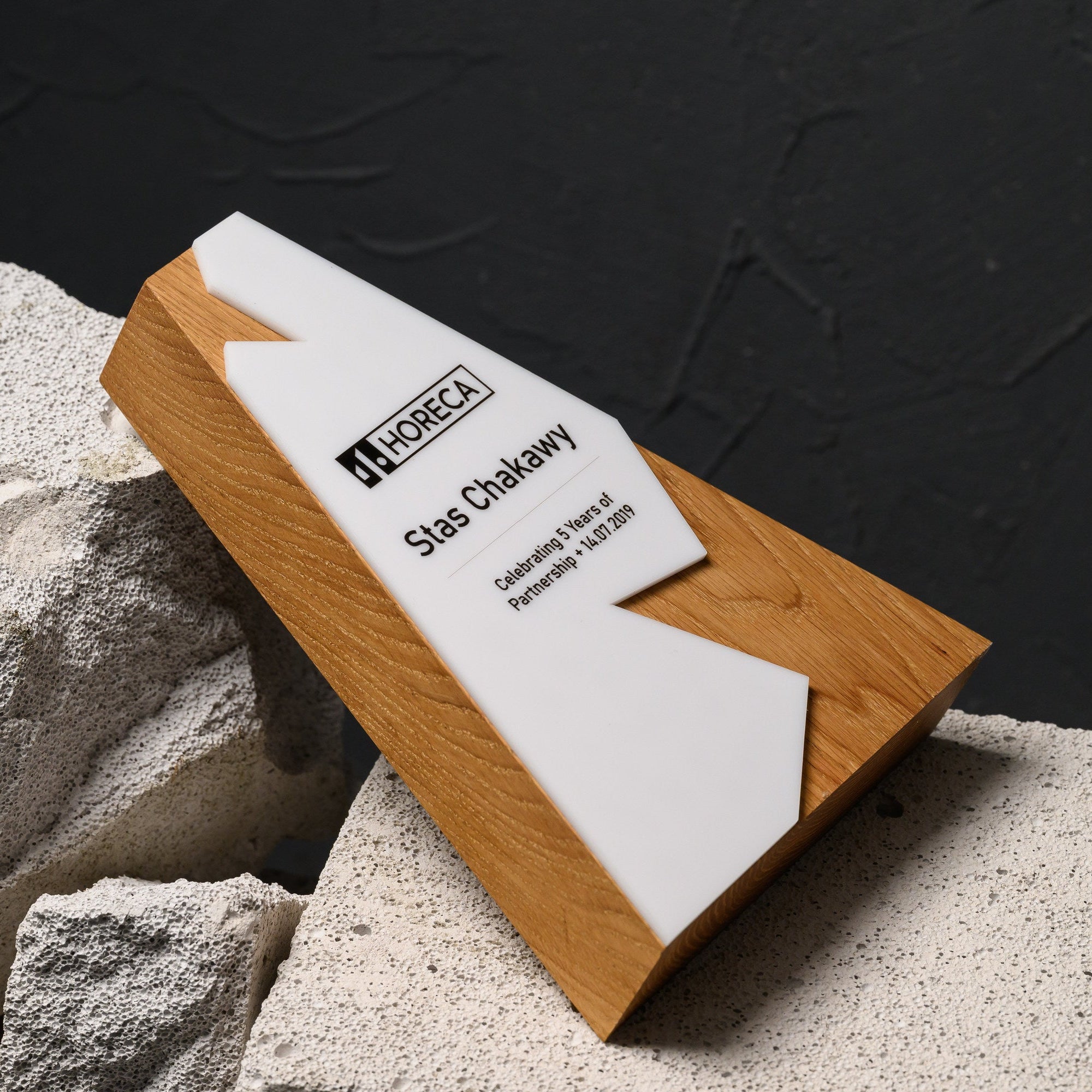 Award lying at an angle on stone, showing the full peak silhouette and the printed panel