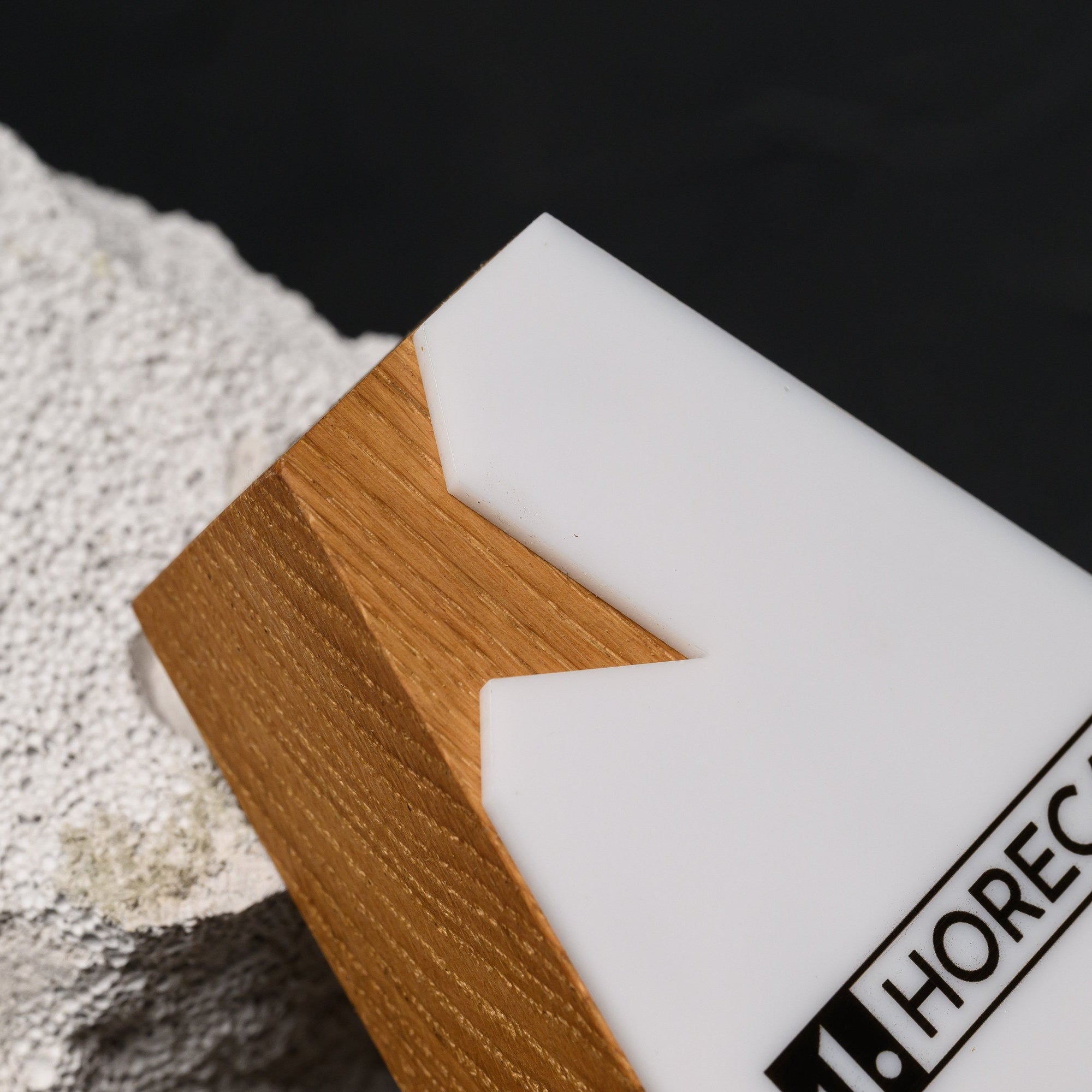 Macro of the angular notch where the white acrylic steps across the oak edge