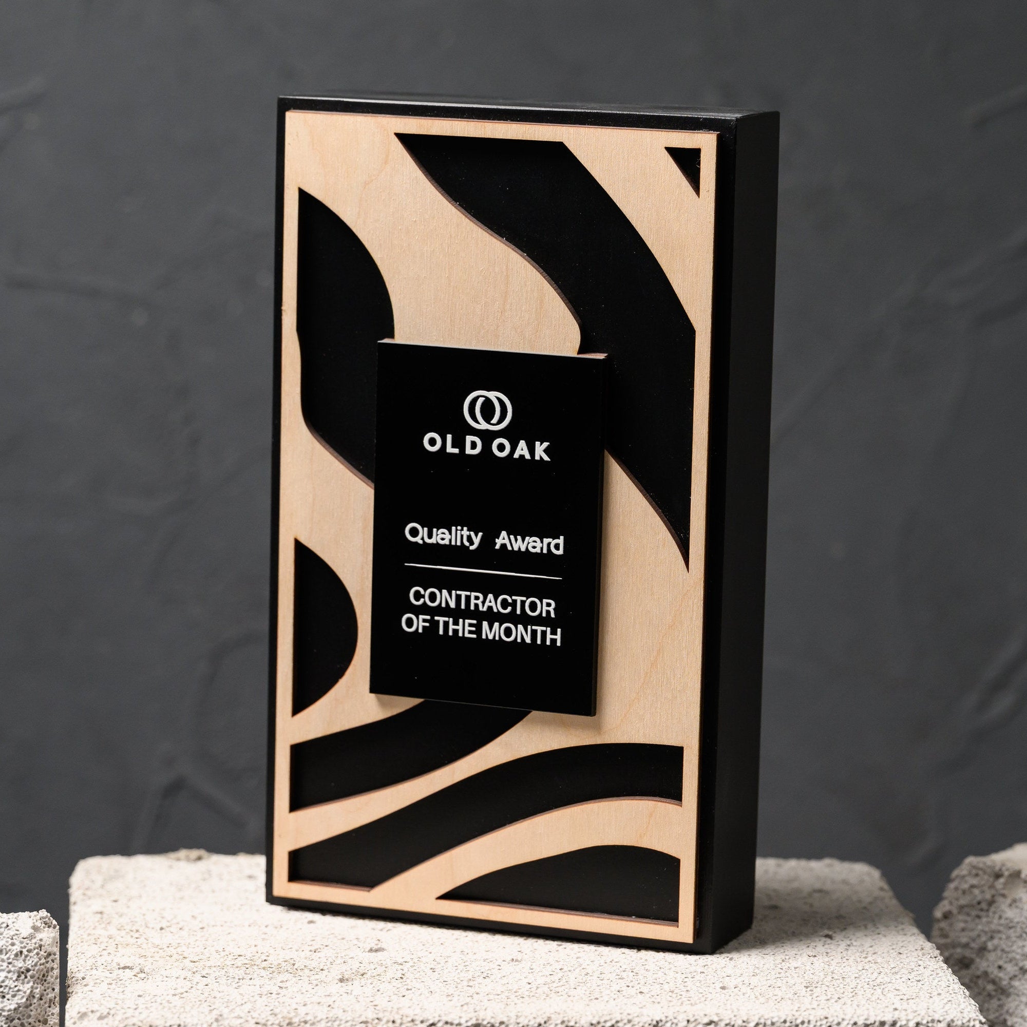 Three quarter view of the plaque showing the plywood overlay and the black acrylic name plate