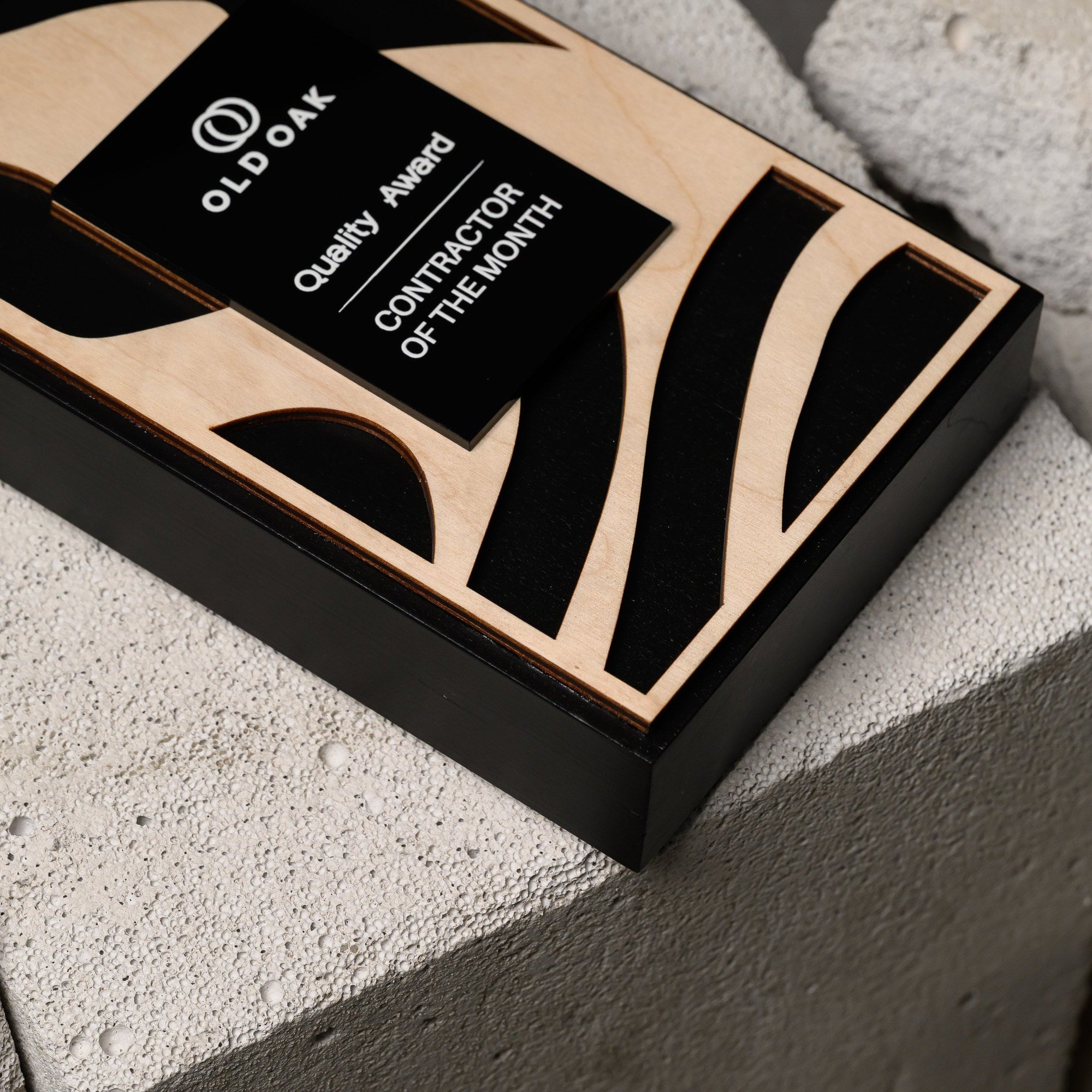 The award lying flat on stone blocks, seen from above with the full cut pattern visible
