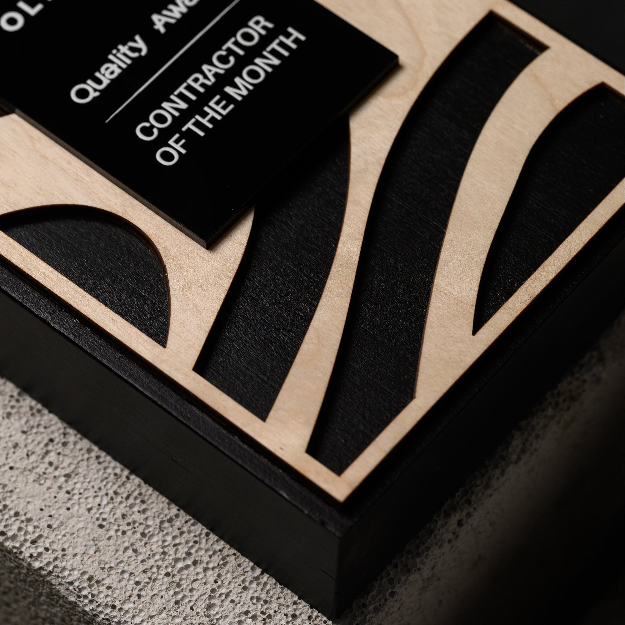 Macro of the laser cut plywood shapes with visible ply edges and the black surface beneath