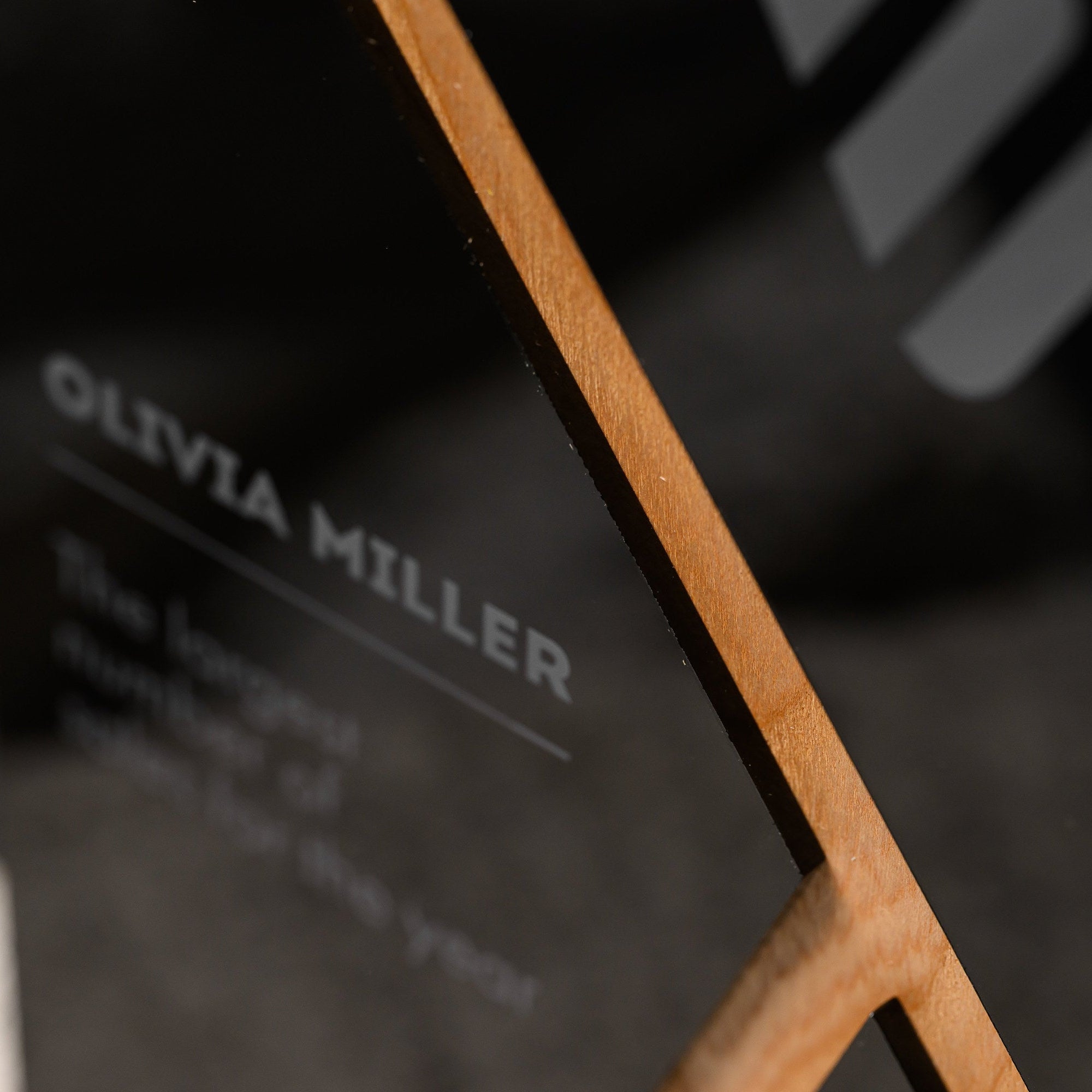 Macro of the narrow oak strut running diagonally across the gloss black acrylic