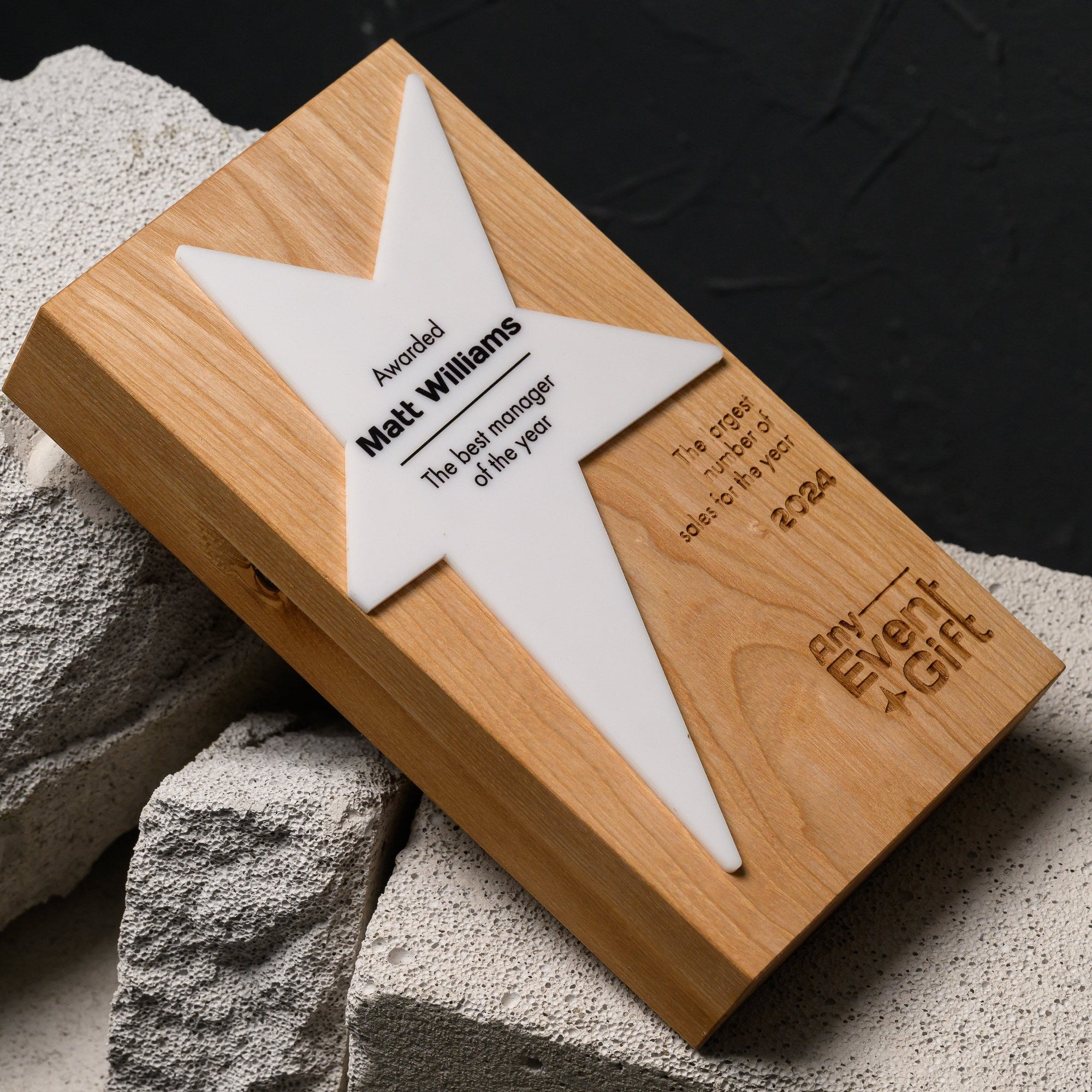 Macro of laser engraving in oak showing the achievement line, the year and a company logo