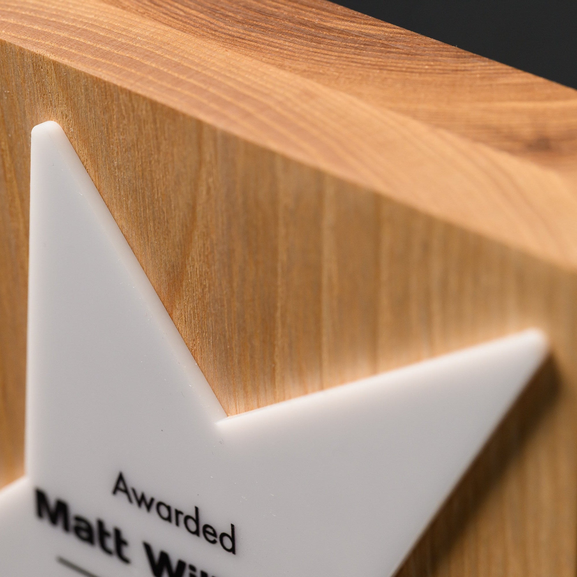 Top edge of the solid oak block showing grain, thickness and one point of the acrylic star