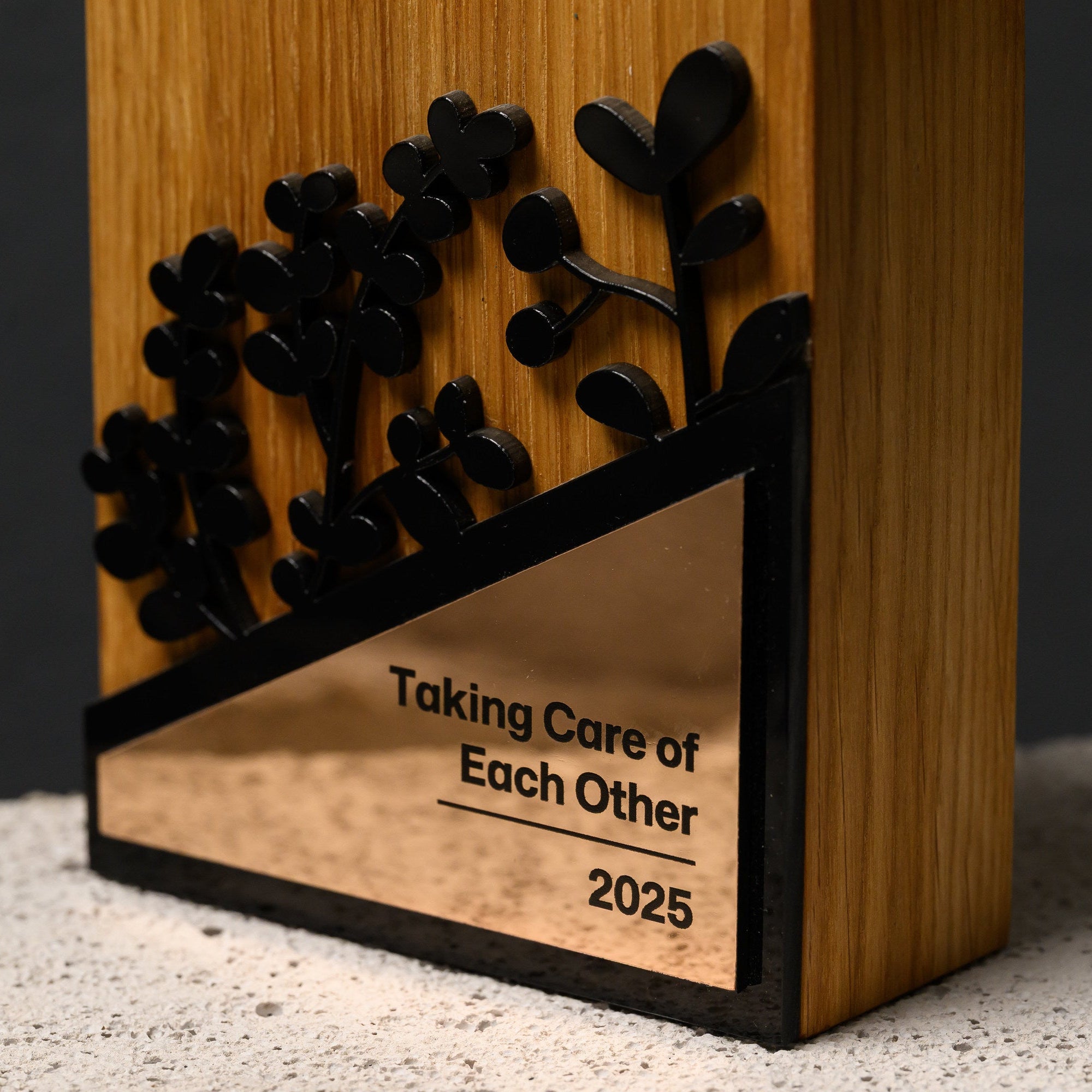 Front detail of the gold mirror acrylic plate with UV-printed wording, framed in black acrylic