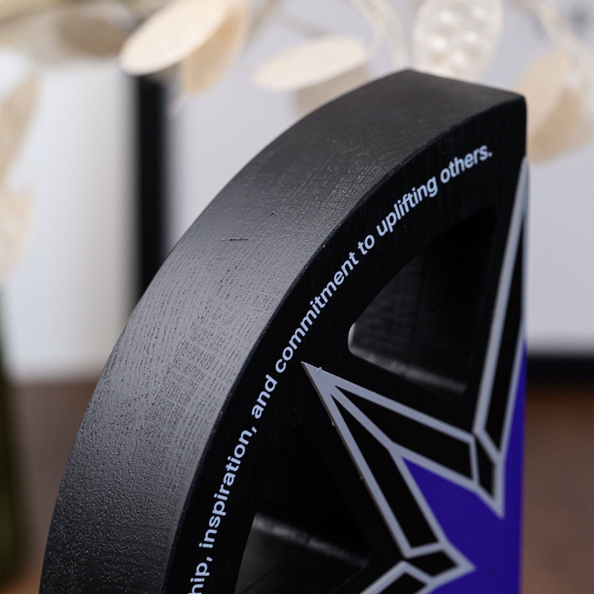 Detail of the printed dedication line following the curved upper edge of the black oak arc