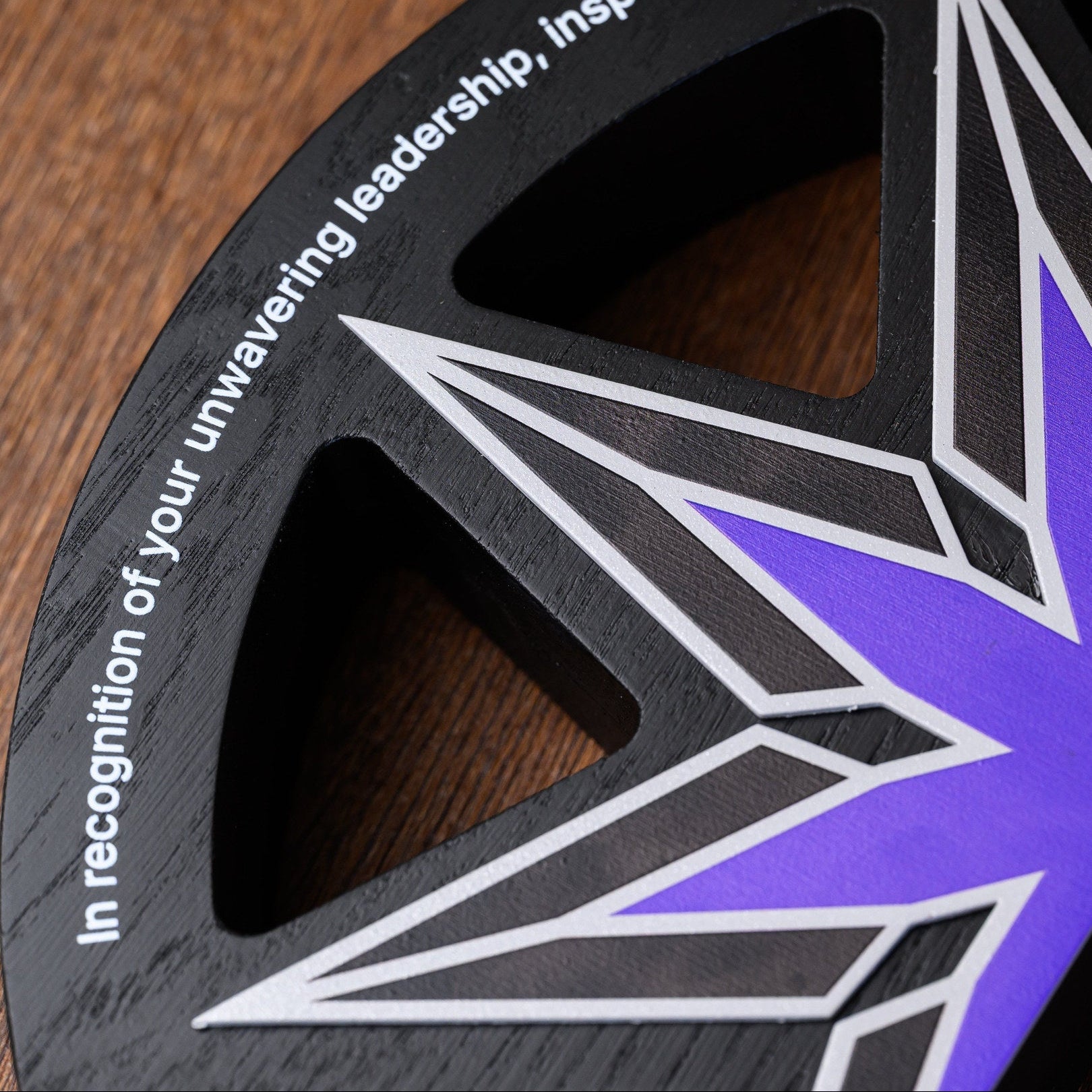 Star award lying on a desk surface, showing the cut-out segments behind the printed steel starburst