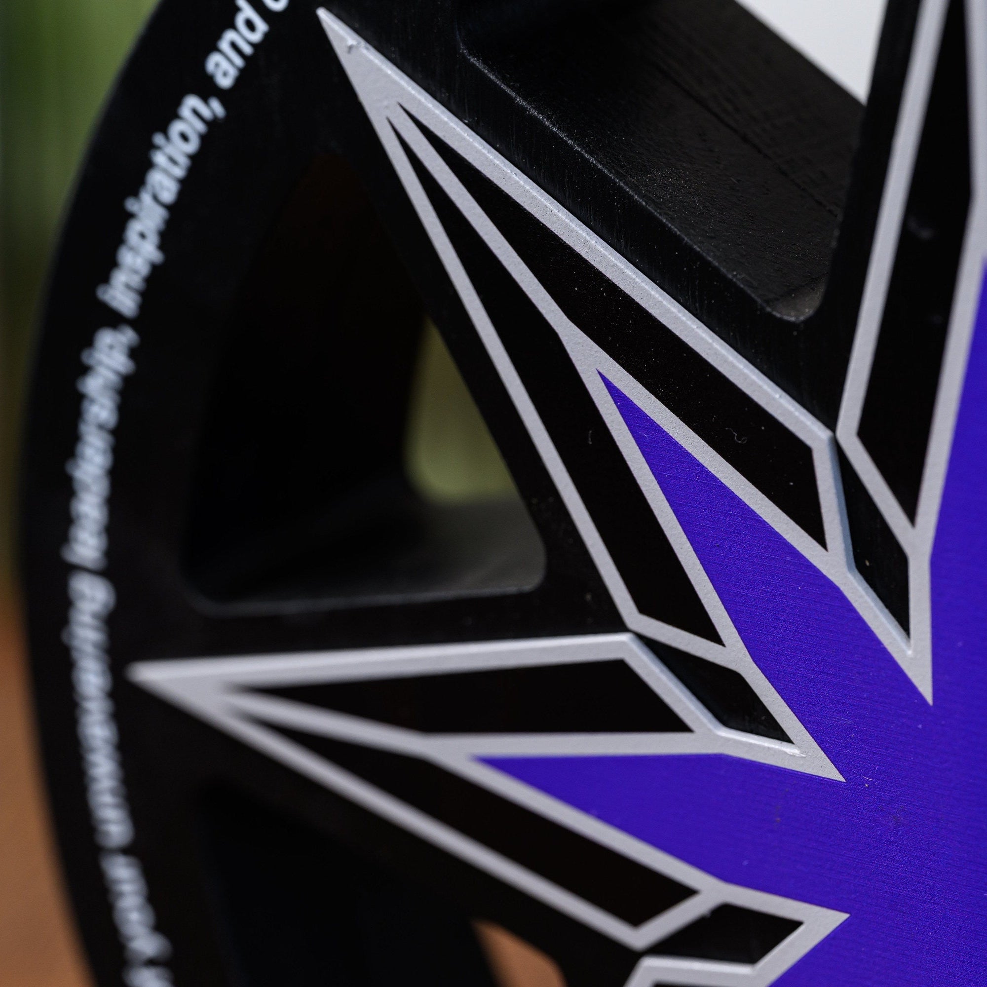 Macro of the UV-printed starburst showing the gradient fill and fine outline detail on steel