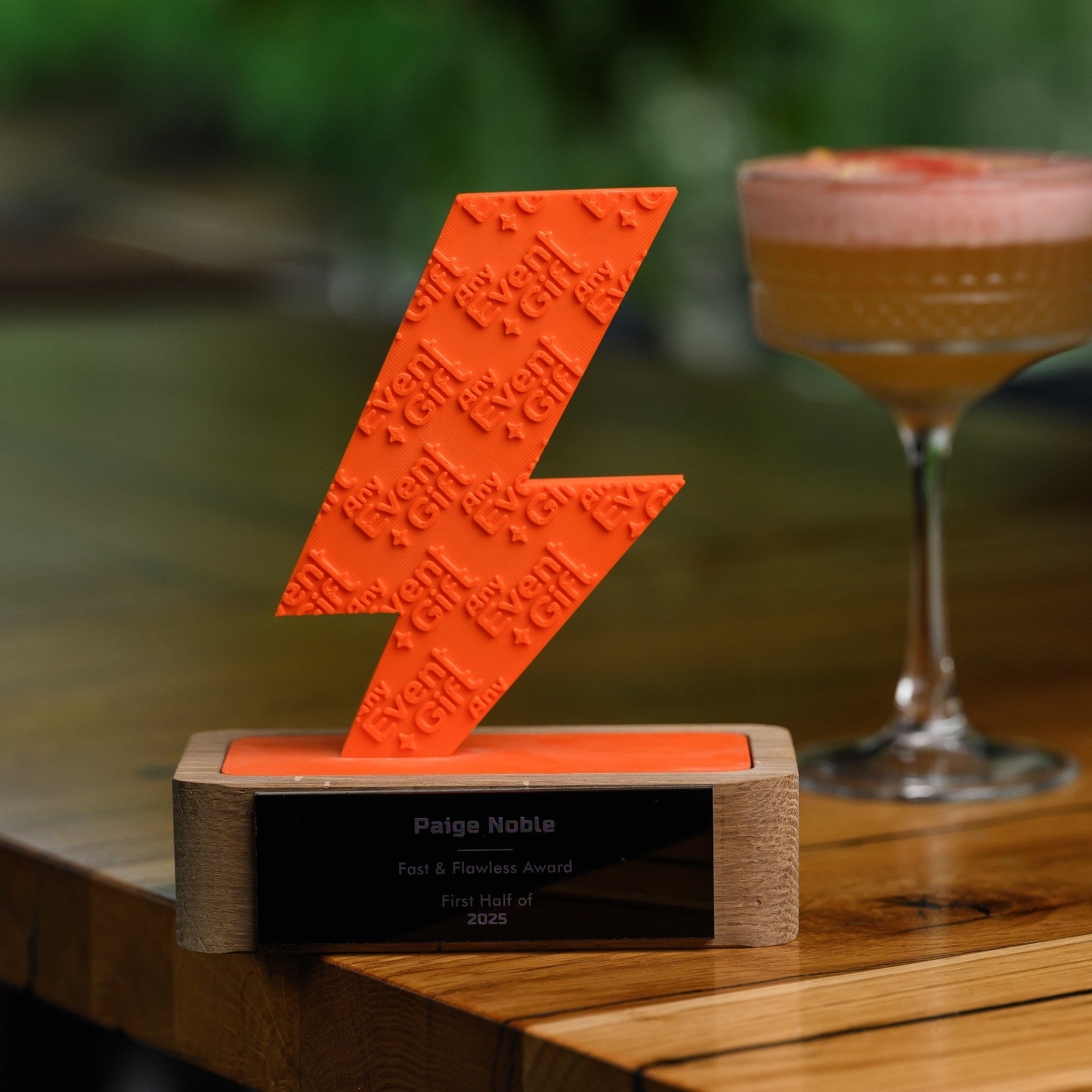 Closer view of the 3D printed trophy on an oak counter, with the engraved plate clearly readable
