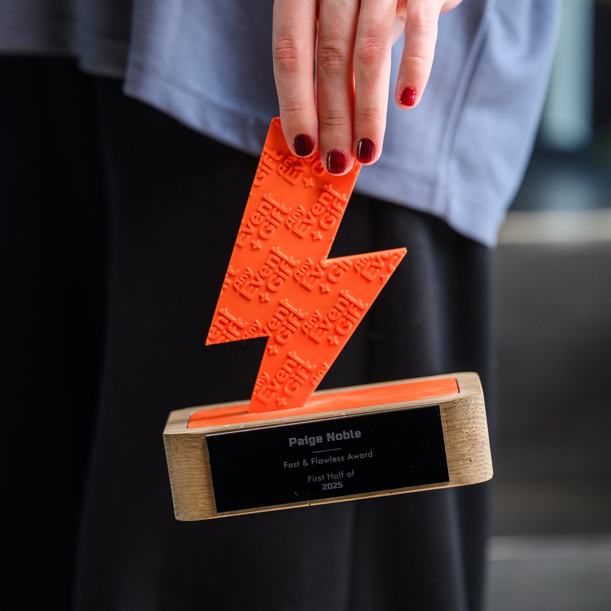 Fingers lifting the printed element out of its seat, showing how the figure sits in the base