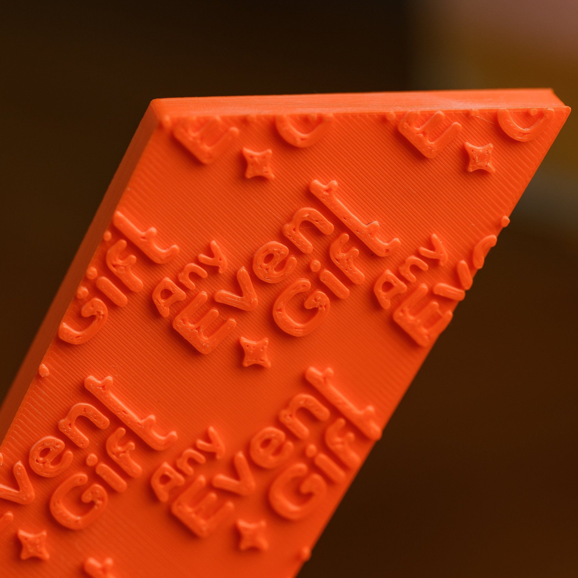 Macro of the raised logo pattern modelled across the printed surface, showing print layer texture