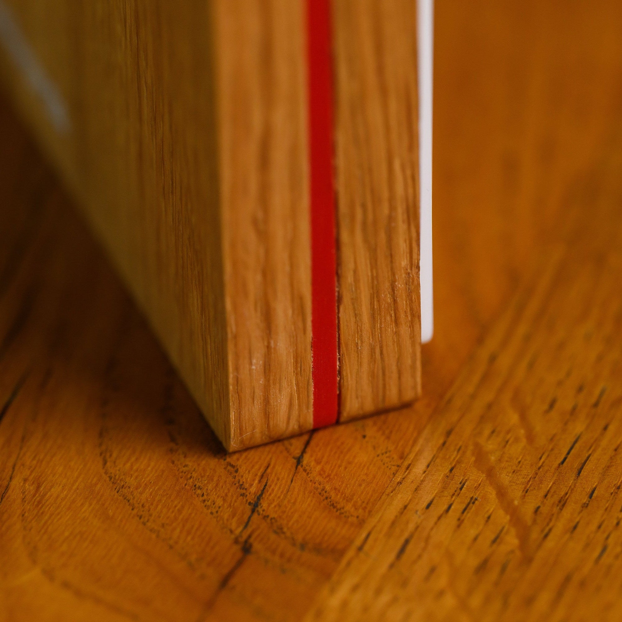 Macro of the base edge showing the oak, coloured acrylic and white acrylic layers stacked