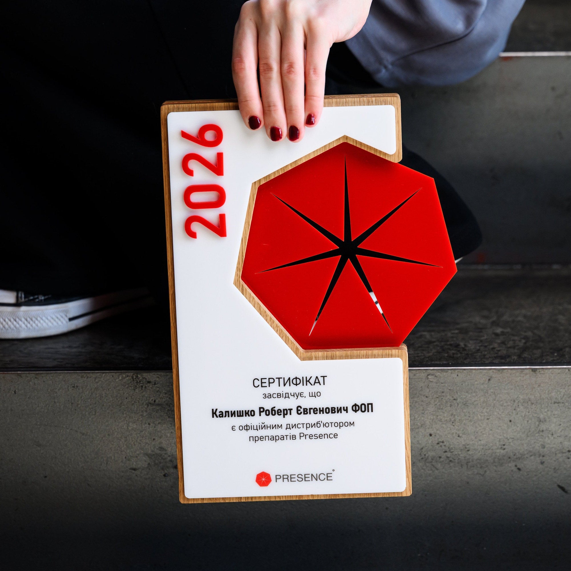Top-down view of the award plaque held against a dark surface, with the full front face visible