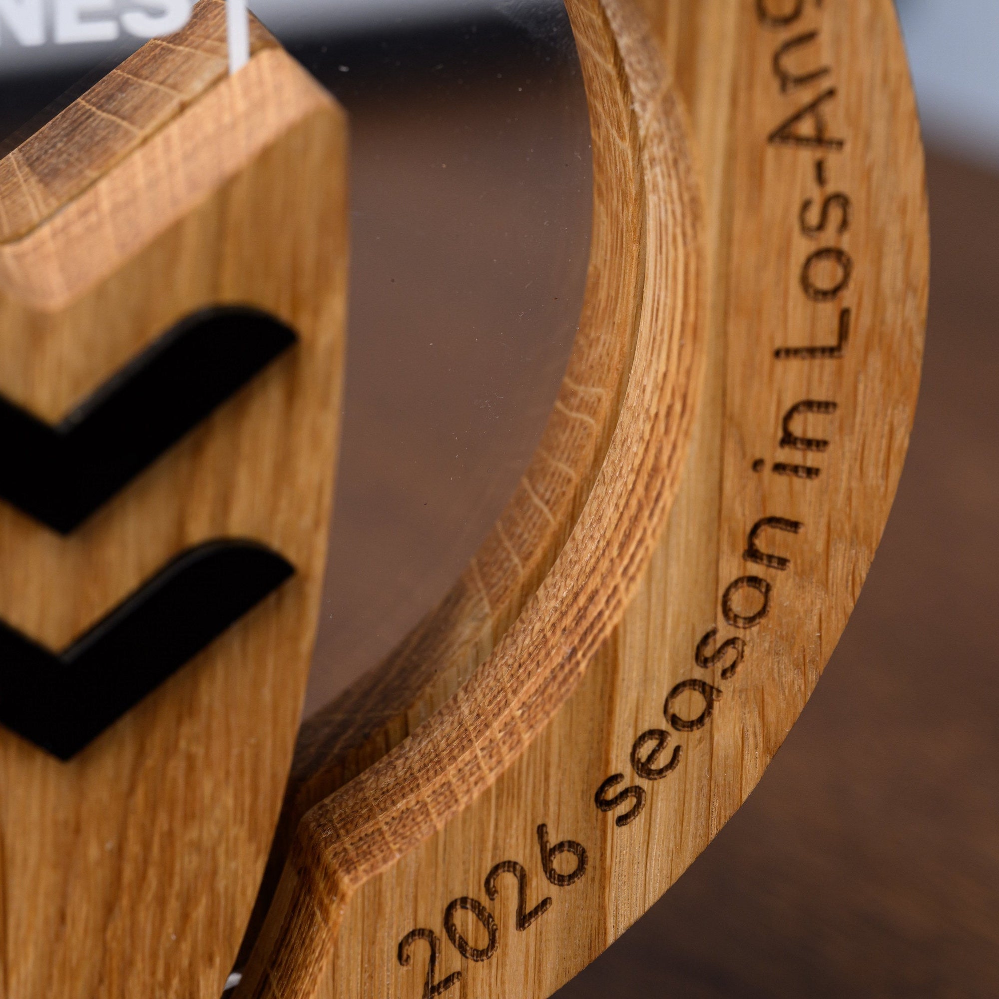 Engraved season and location wording running around the oak frame of the personalised surfing award
