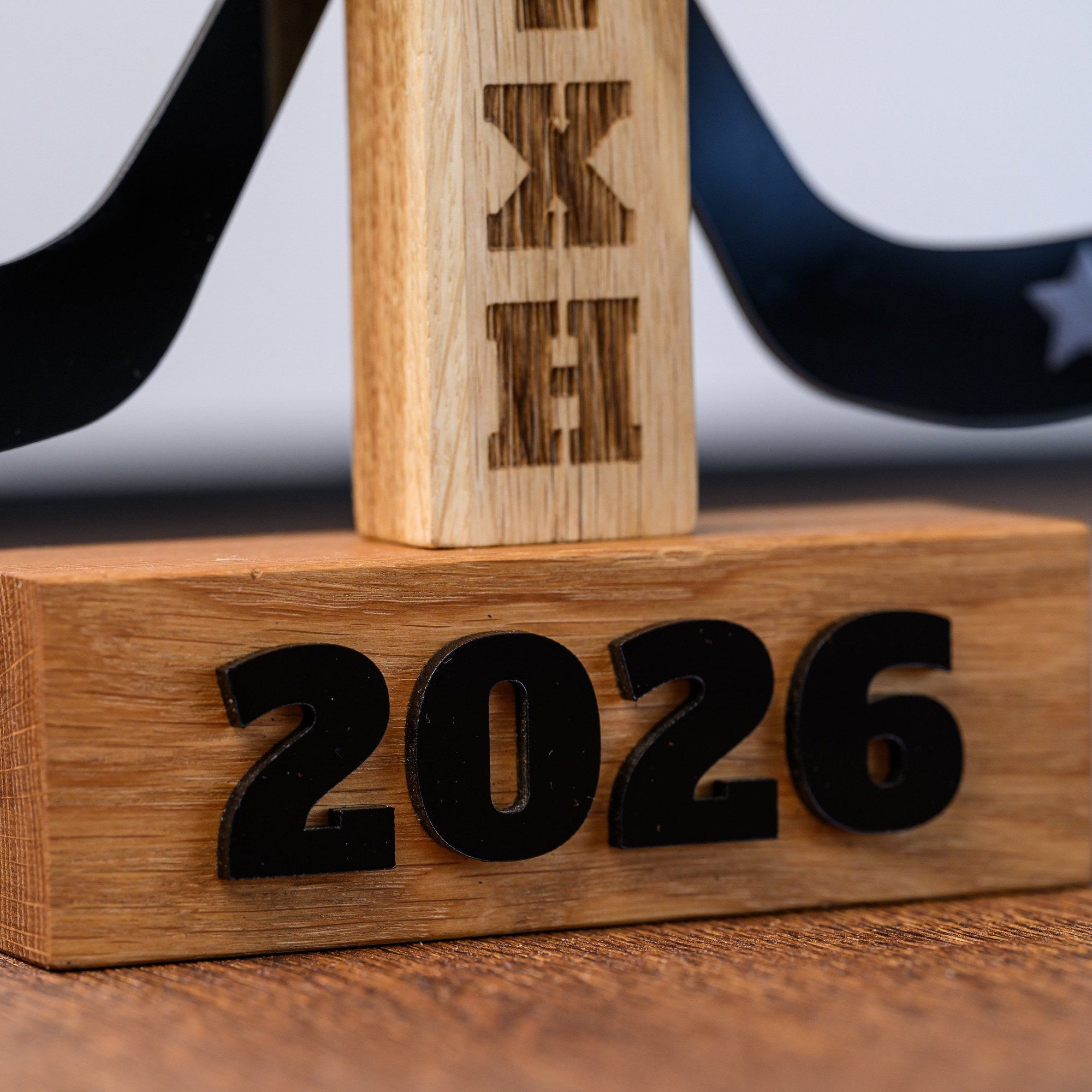 Solid oak plinth with dimensional black acrylic numerals showing the season year of the award