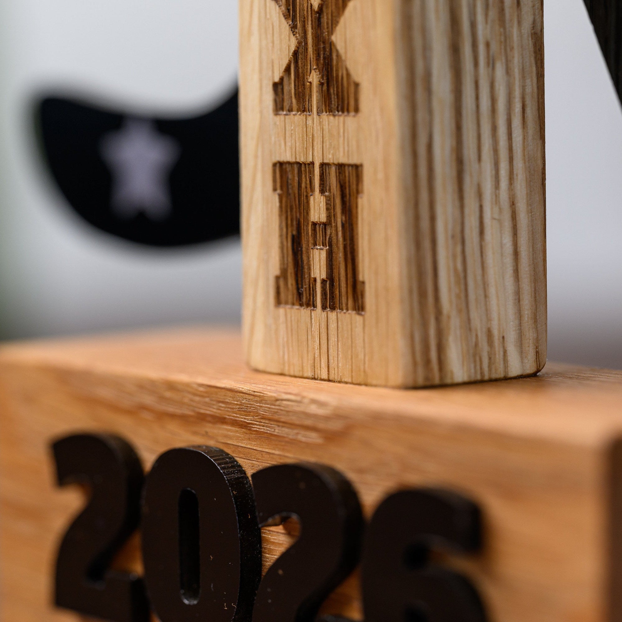 Club initials engraved vertically into the oak stem that joins the trophy cup to its base