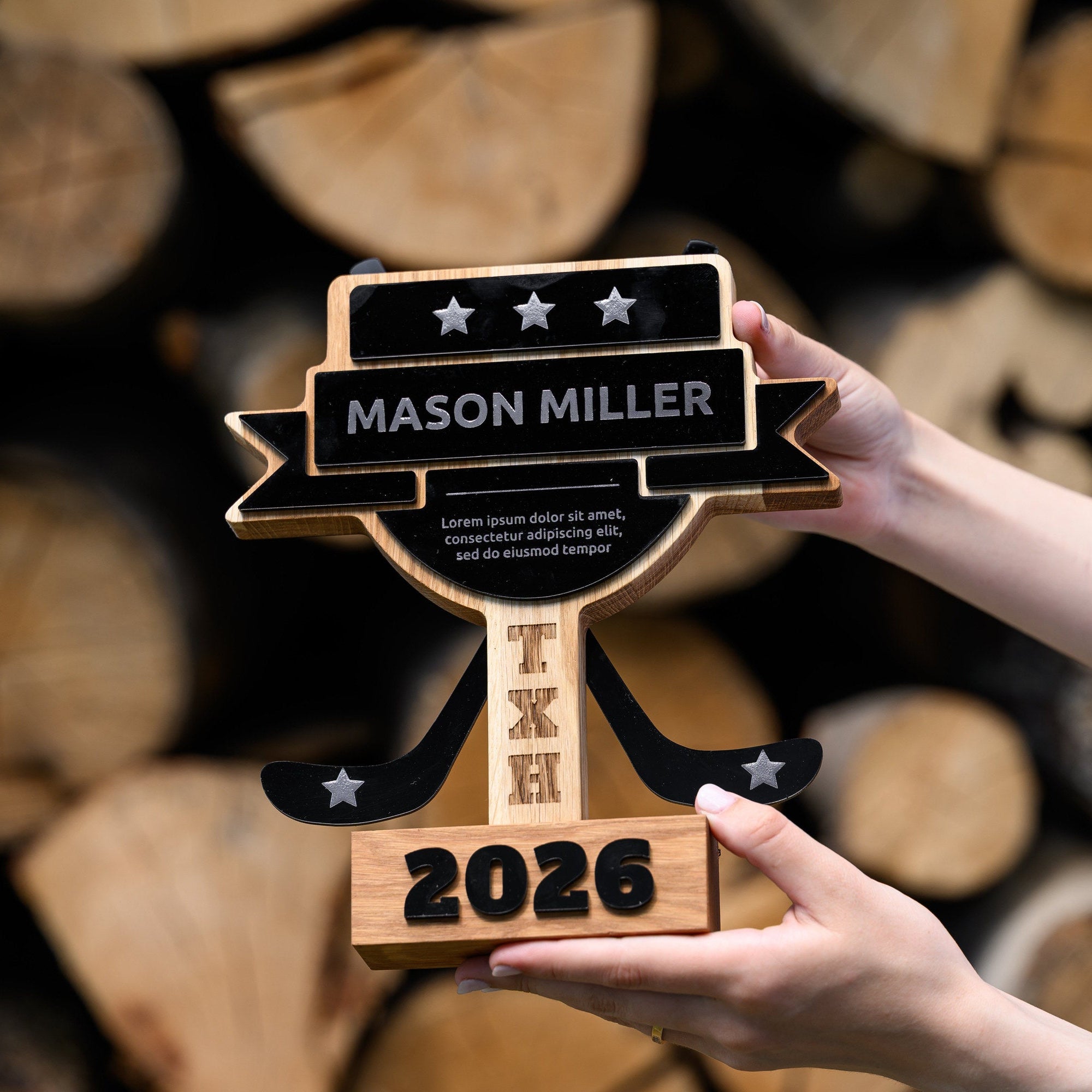 Angled view of the hockey award held in two hands, showing the star plate and crossed acrylic sticks