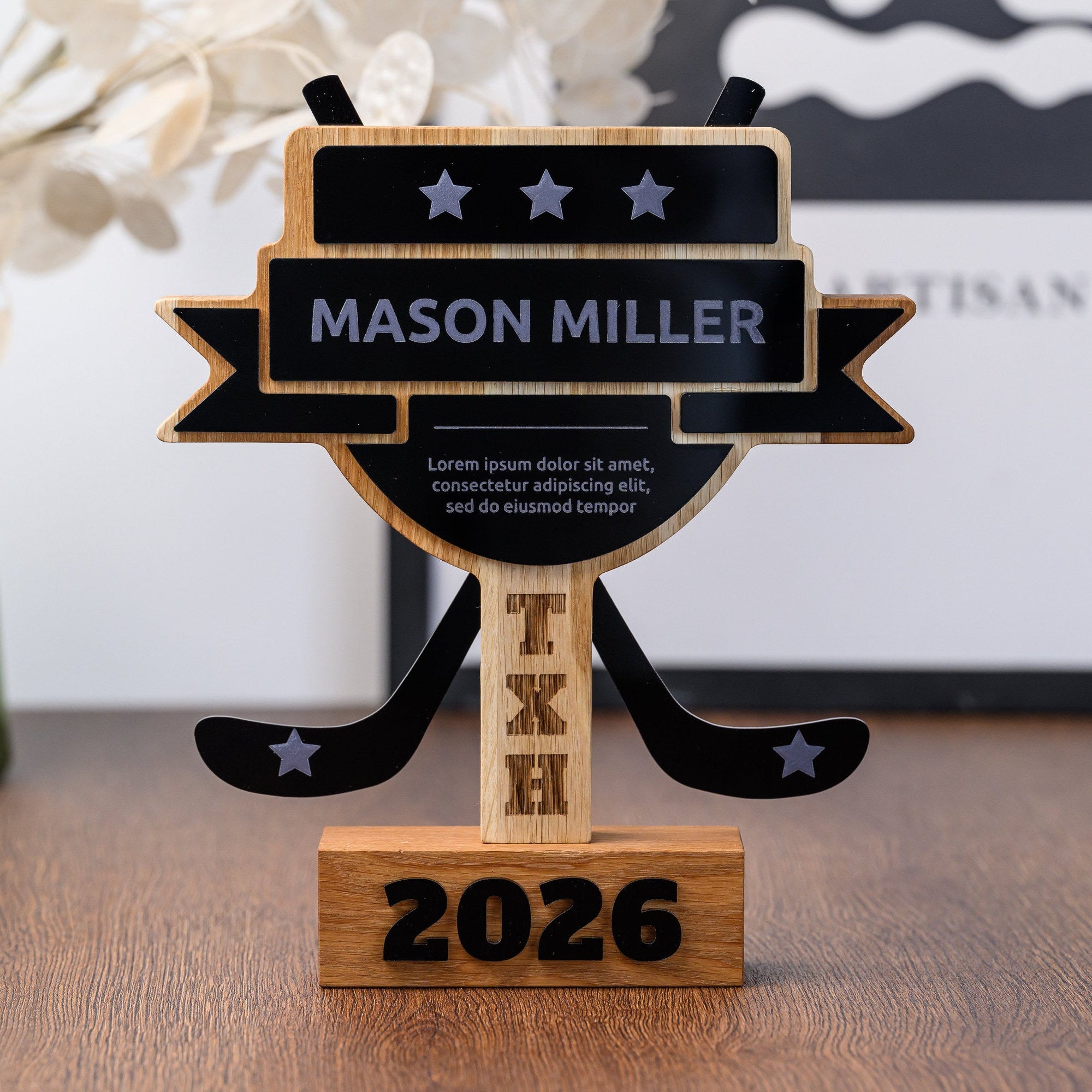 Custom hockey trophy in oak with black acrylic name banner and crossed sticks, standing on a desk