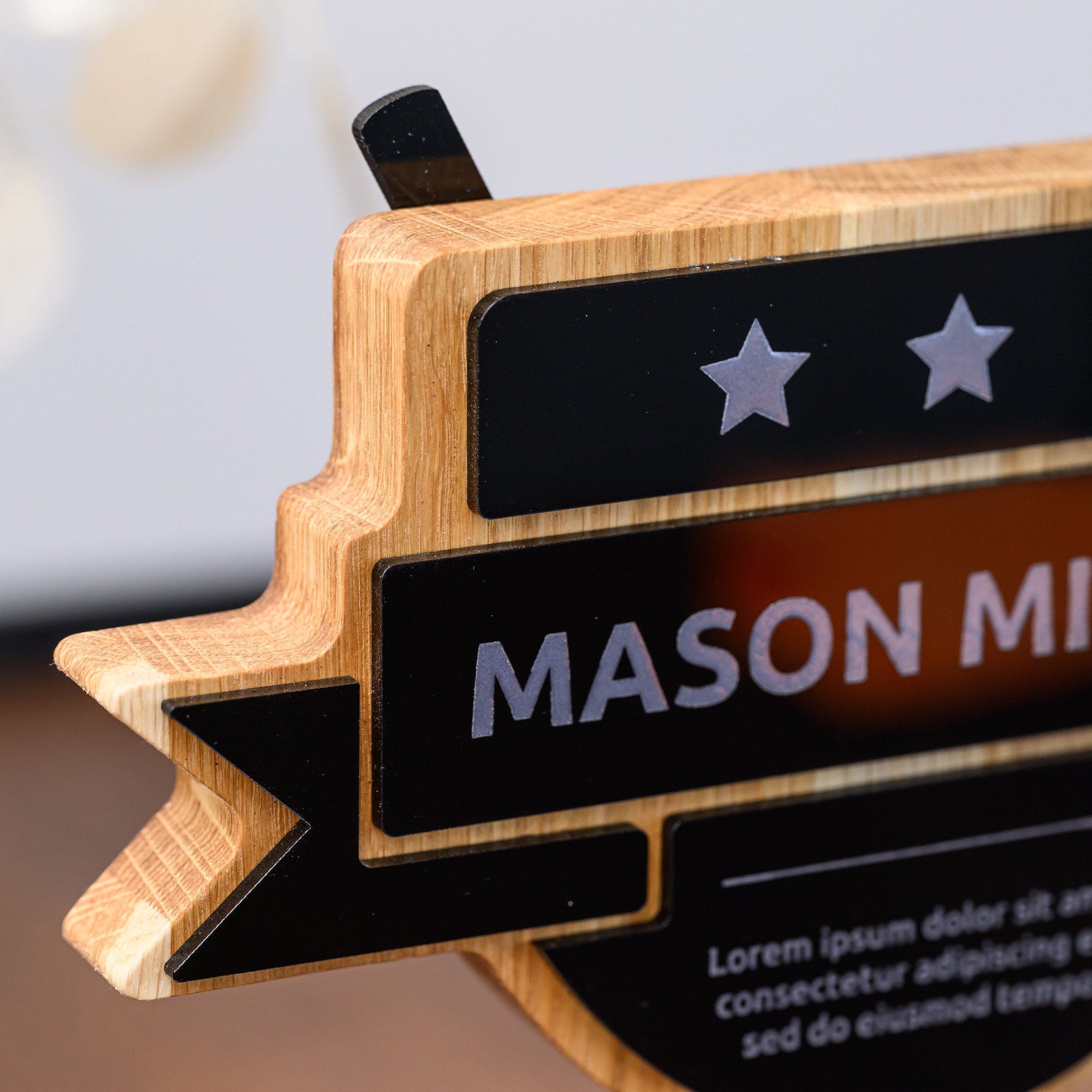 Close-up of the three engraved stars and the raised black acrylic name ribbon on the trophy front